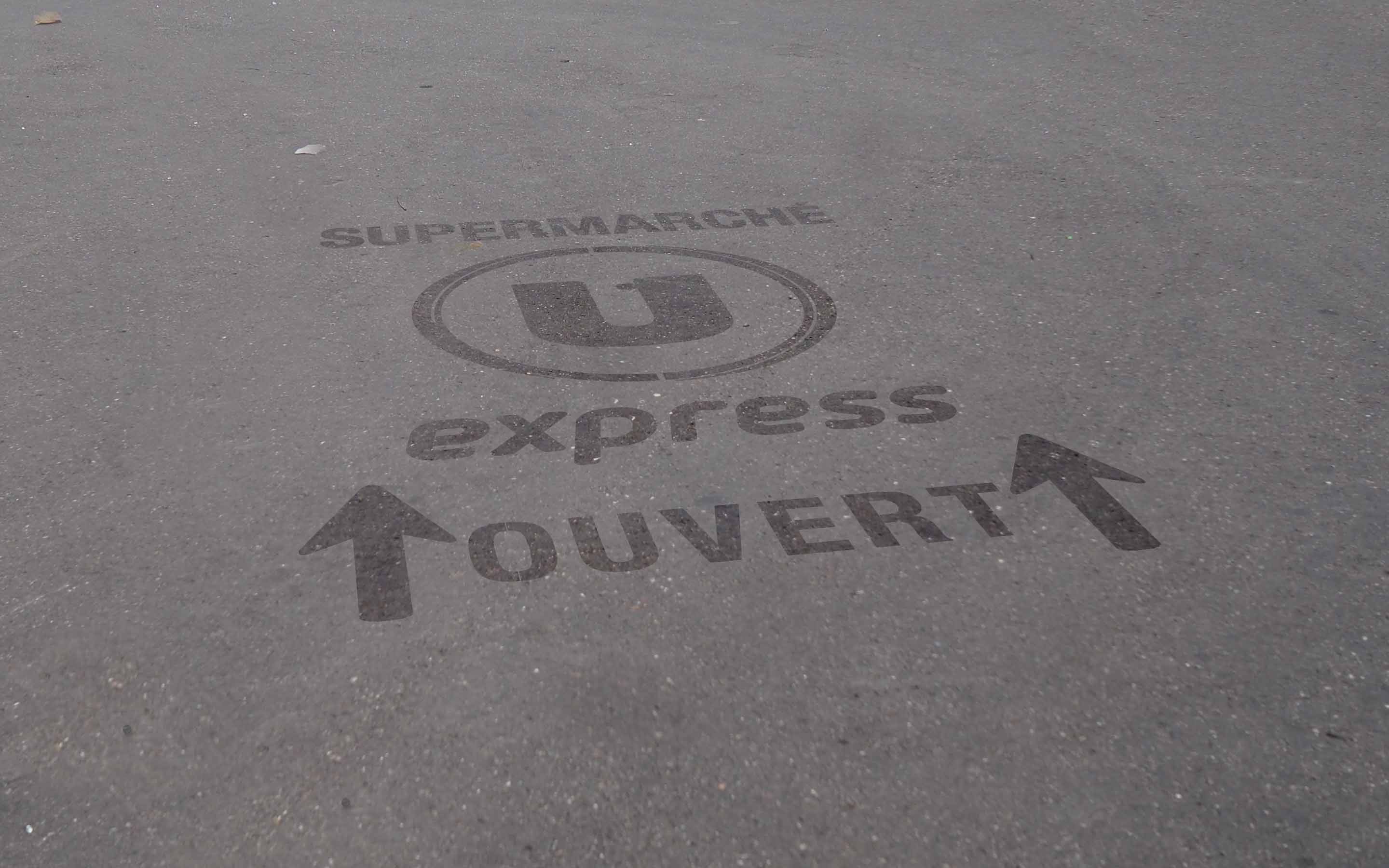 Marquage au sol clean-tag sur bitume pour les magasins U