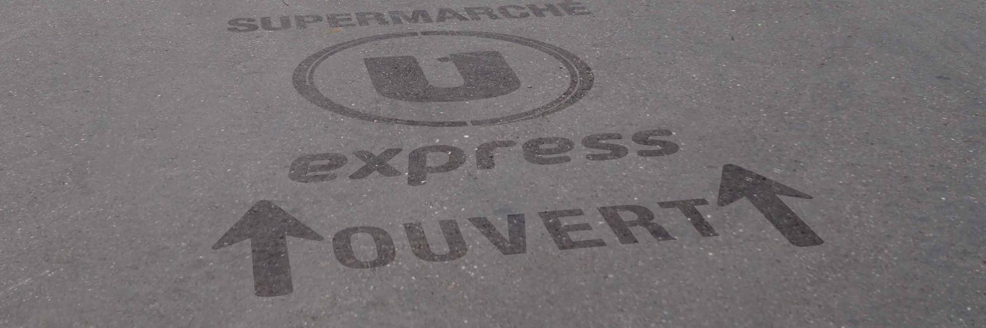 Marquage au sol clean-tag sur bitume pour les magasins U
